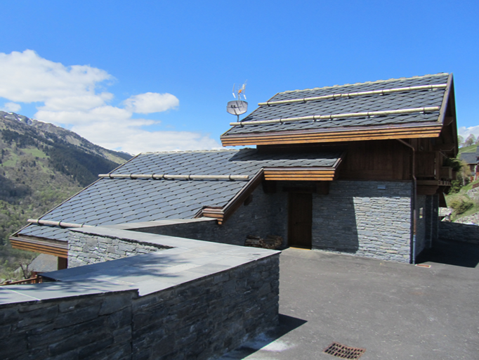 Edificio de montaña en los Alpes franceses con cubierta y paramento de pizarra natural
