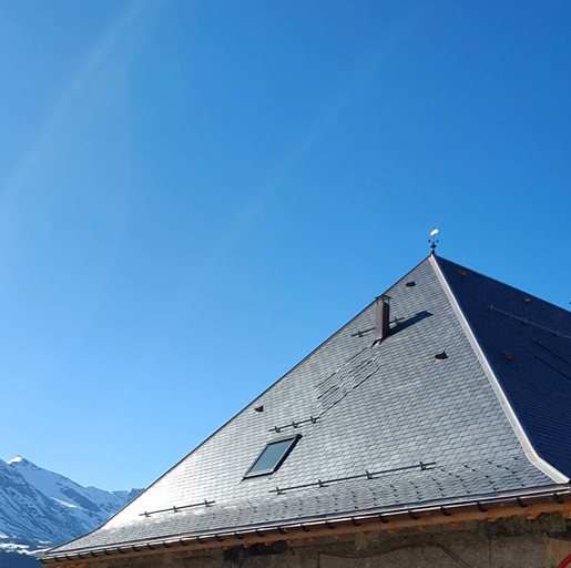 Cubierta de pizarra natural de un chalet alpino recortada sobre el cielo de los Alpes franceses