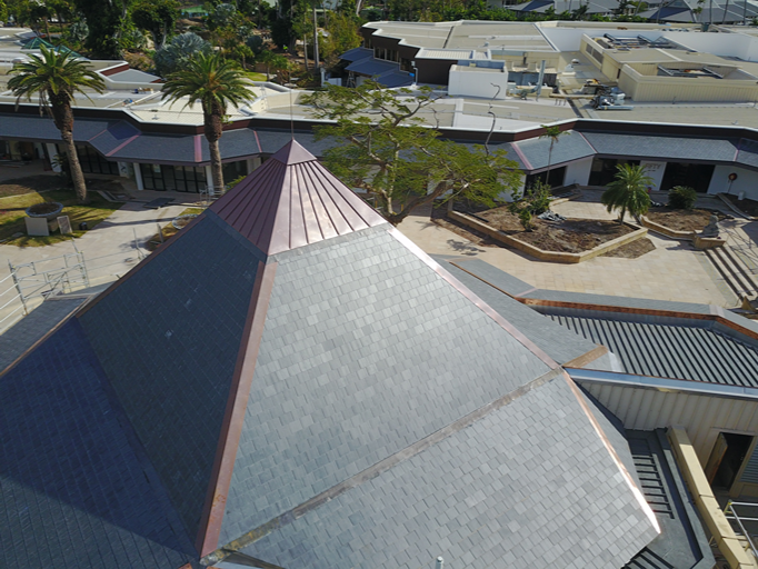 Tejado piramidal de pizarra natural entre palmeras en un resort de Australia