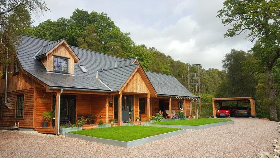 Casa de madera en Escocia con tejado de pizarra natural y porche acristalado