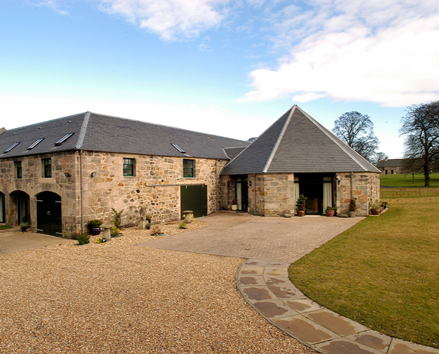 Conjunto rehabilitado de piedra en Dalmeny Steading, Escocia, con cubiertas de pizarra natural