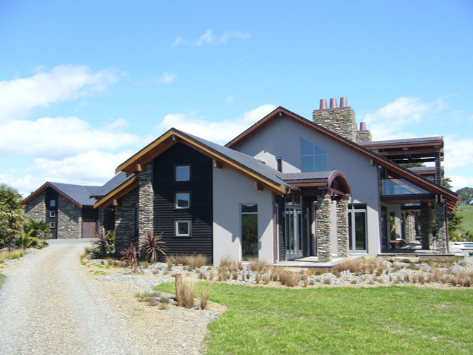 Vivienda contemporánea en Nueva Zelanda con zócalo de piedra y tejado de pizarra natural