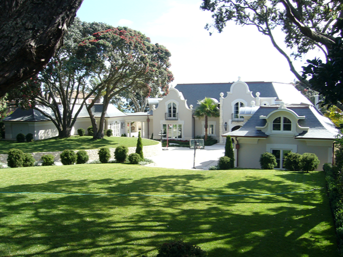 Residencia blanca en Nueva Zelanda con buhardillas y cubierta de pizarra natural