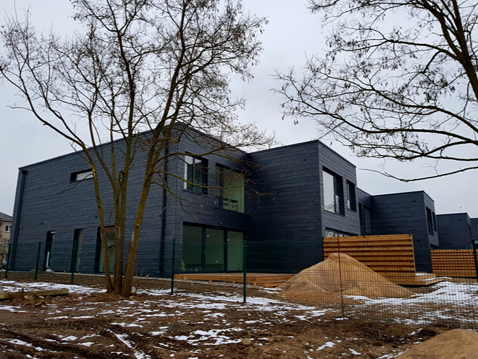 Conjunto residencial en Lituania con fachadas de pizarra natural en invierno