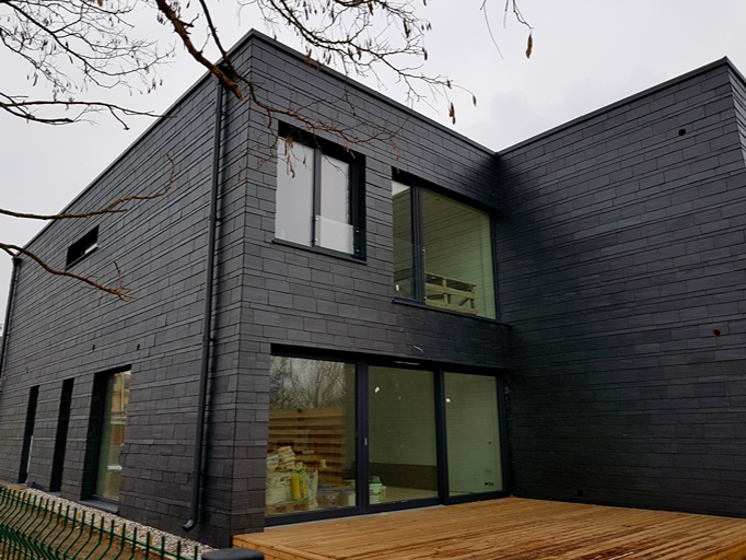 Detalle del revestimiento de pizarra natural en la fachada de una vivienda en Lituania
