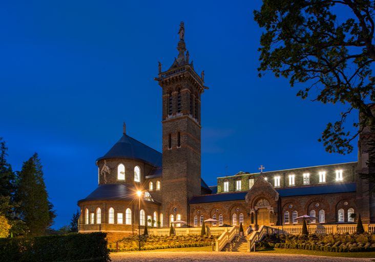 St. Joseph's College de Mill Hill, Londres, al anochecer con sus cubiertas de pizarra natural iluminadas